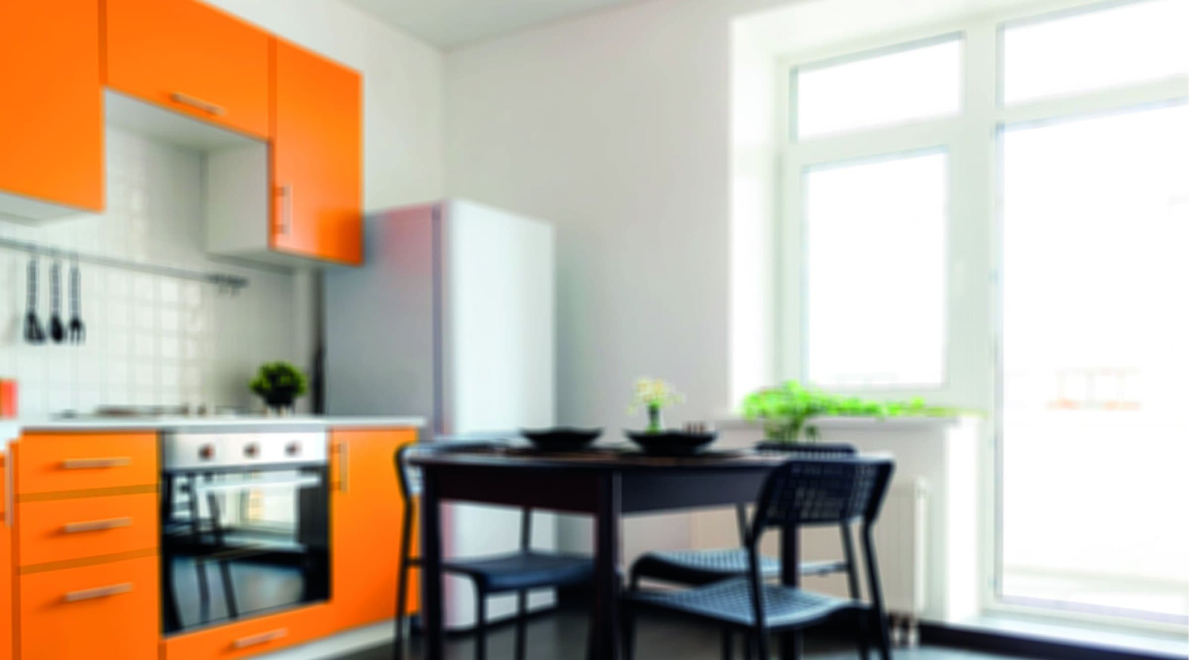 A kitchen with orange and white cabinets, a black table and a large window, shown as the product's context of use.